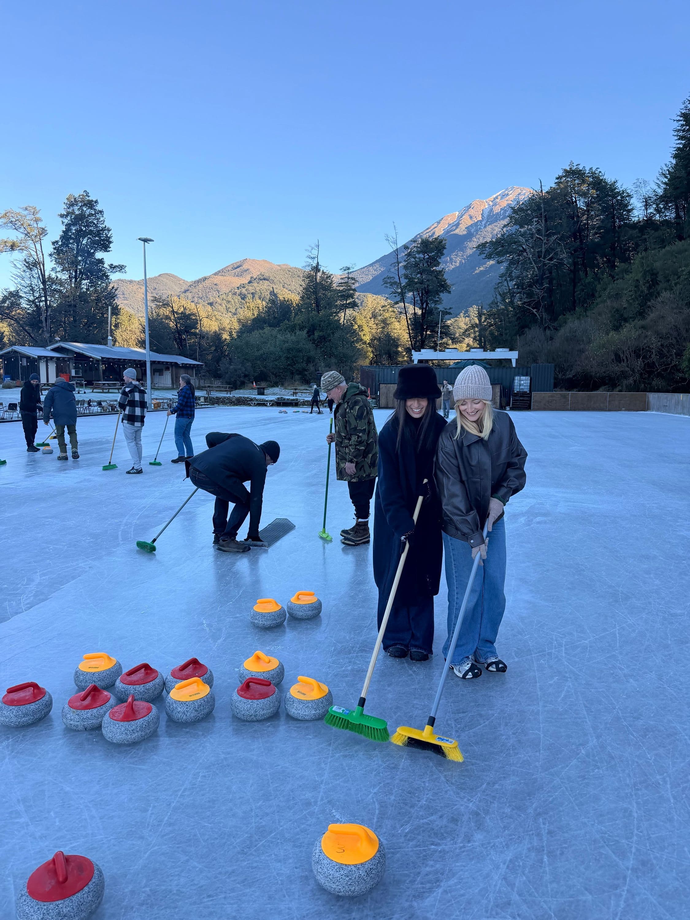 Two Appetise team members curling outdoors
