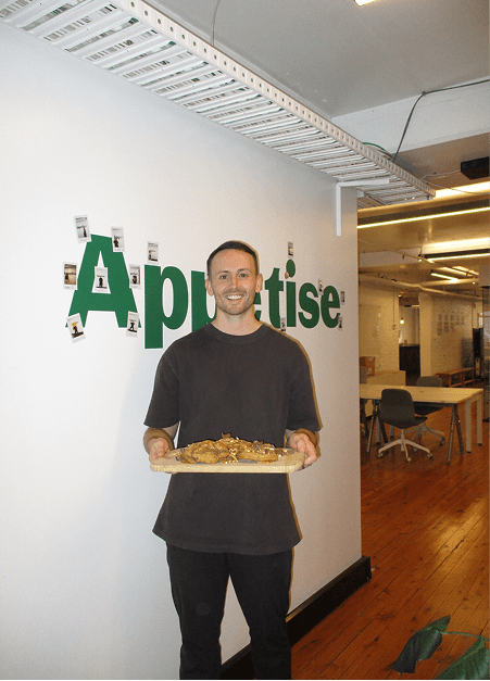 Appetise team member holding a tray of freshly baked treats